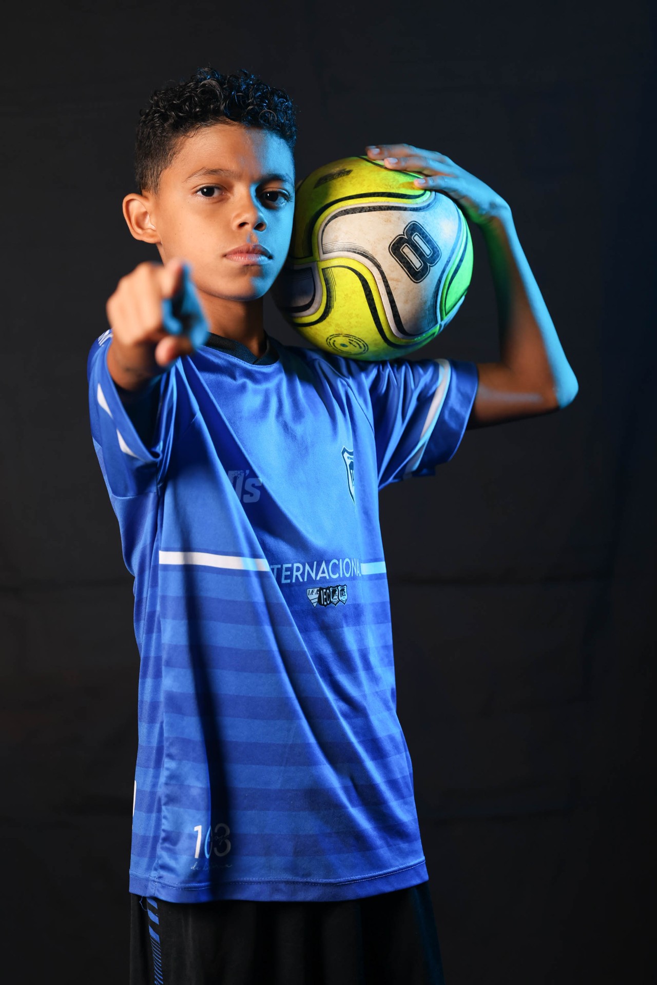 Retrato de jovem atleta de futebol com bola no ombro