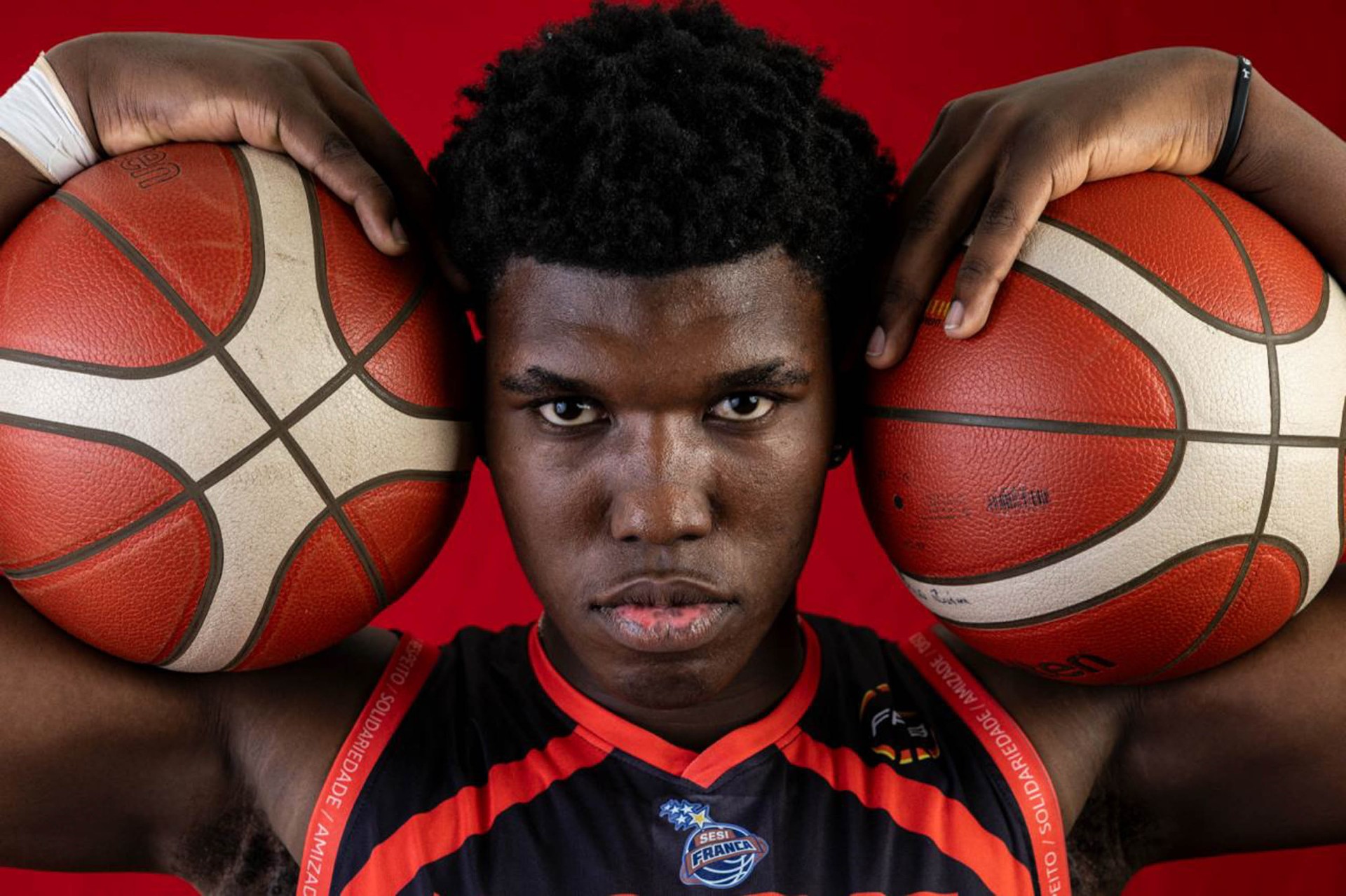 Retrato de atleta de basquete do SESI Franca com duas bolas